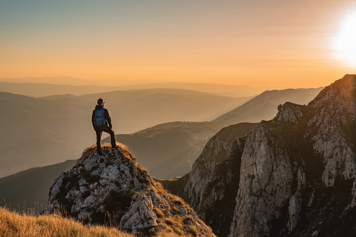 Inspirational image of a person scaling a mountain.